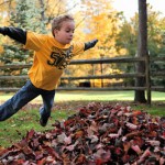 Kid jumping in leaves