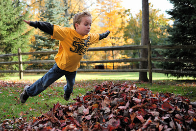 Kid jumping in leaves